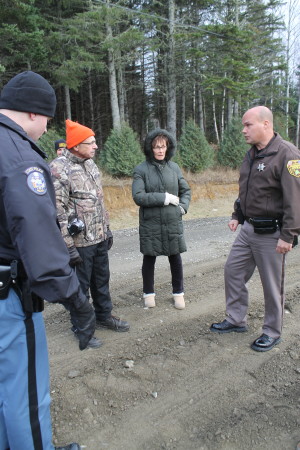 John Ezzy, left, and his wife Anne, talk with a Maine State Police trooper and Aroostook County Sheriff's Department deputy Monday, Oct. 31, following an incident on Pelletier Avenue, in which an abutting landowner plowed up a section of disputed road and allegedly assaulted a passerby. (Don Eno | SJVT/FhF)