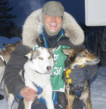 Martin Massicotte of St.-Tite,Quebec, was all smiles with his lead dogs Magic and Amick after claiming their seventh Can-Am Crown International Sled Dog Race victory early Monday morning. Massicotte and his team crossed the Fort Kent finish line at Lonesome Pine Ski Trails at 5:45 a.m. Monday, completing the 250-mile race with a run time of 28:57:47. (BDN photo | Julia Bayly)