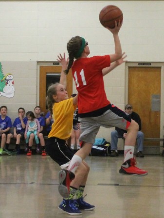 Larissa Daigle of the Bulls sails past Scotia Martin of the Lakers during a Fort Kent Parks and Recreation Department basketball tournament on Thursday, March 9. (Jessica Potila | SJVT/FhF)