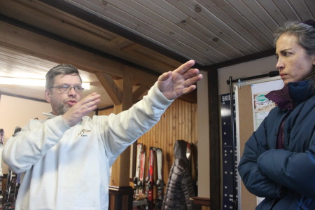 Jeffrey McRobbie of Wayne, left, explains his collision with a snowmobile in last year's Can-Am to spectator Barbara Daggett, at Can-Am headquarters, Saturday, March, 4, in Fort Kent. (SJVT/Fhf photo | Don Eno)